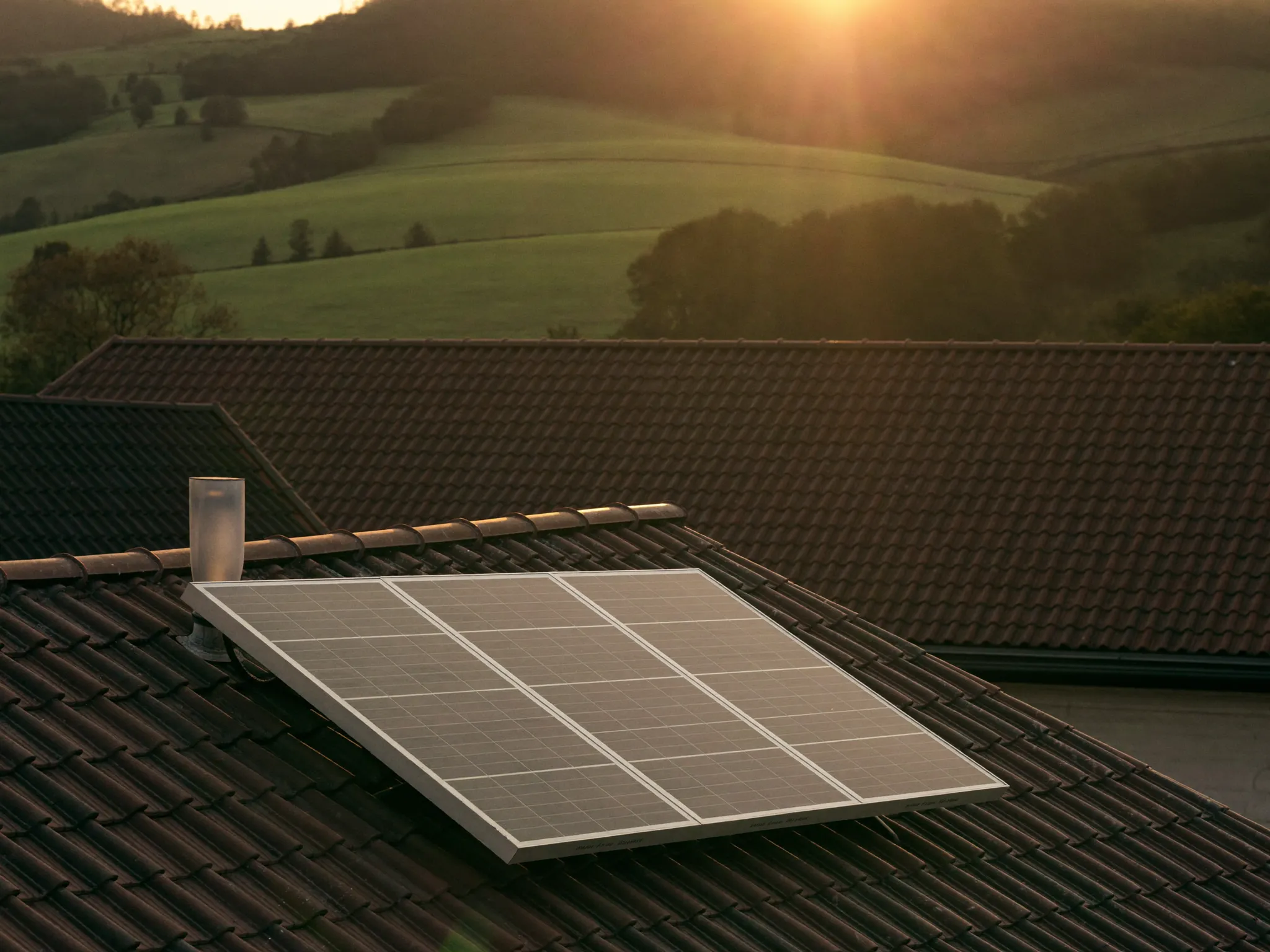 Solarthermie-Kollektoren auf einem Dach im Abendlicht